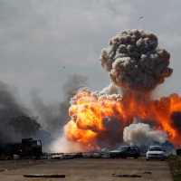 © GORAN TOMAŠEVIČ, Reuters: Automobily vojska libyjského vůdce Muammara Kaddáfího explodují po leteckém bombardování koalice mezi městy Benghází a Ajdabiyah. Libye, 20. 3. 2011 / Cars belonging to the army of Libyan leader Muammar Kaddafi explode as a result of coalition bombing between Benghazi and Ajdabiyah, Libya, 20 March 2011