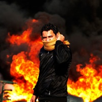 © GORAN TOMAŠEVIČ, Reuters: Demonstrant před hořící barikádou v Káhiře. Egypt, 28. 1. 2011 / Demonstrator in front of a burning barricade in Cairo, Egypt, 28 January 2011