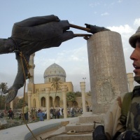 © GORAN TOMAŠEVIČ, Reuters: Americký námořník sleduje svržení sochy iráckého prezidenta Saddáma Husajna na náměstí Firdaus v centru Bagdádu Irák, 9. 4. 2003 / Member of US Marine Corps watches as the statue of Iraqi president Saddam Hussein is pulled down at Firdaus Square in central Baghdad, Iraq, 9 April 2003